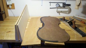 two backs for cellos in the making, with layout template and jointing plane
